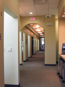 Soffits, arches, and unique lighting break up a long hallway.