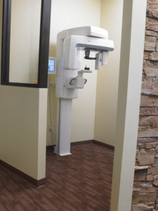 Behind the sleek curved glass wall that separates the reception area from the treatment rooms is a variety of advanced equipment, including this Instrumentarium OP300 system, conveniently located near the operatories.