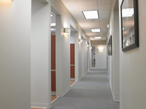 with 10-foot ceilings, clean gray hues on the walls and floors, and wide hallways that contribute to the practice’s open feeling.