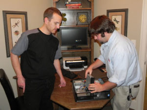 Dr. Patrick Singley talks with Warren Torrey, Equipment Service Technician/CADCAM/CIT/Software, in the treatment planning room about software and hardware integration.
