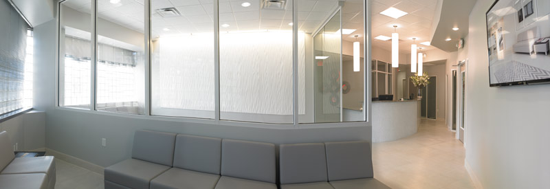 The custom wall art, draws the eye with its soothing texture and bold white hue and ties into the check-in desk design.