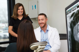 Dr. Sulens and hygienist consult a patient.